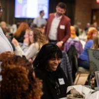 people standing and sitting at luncheon table